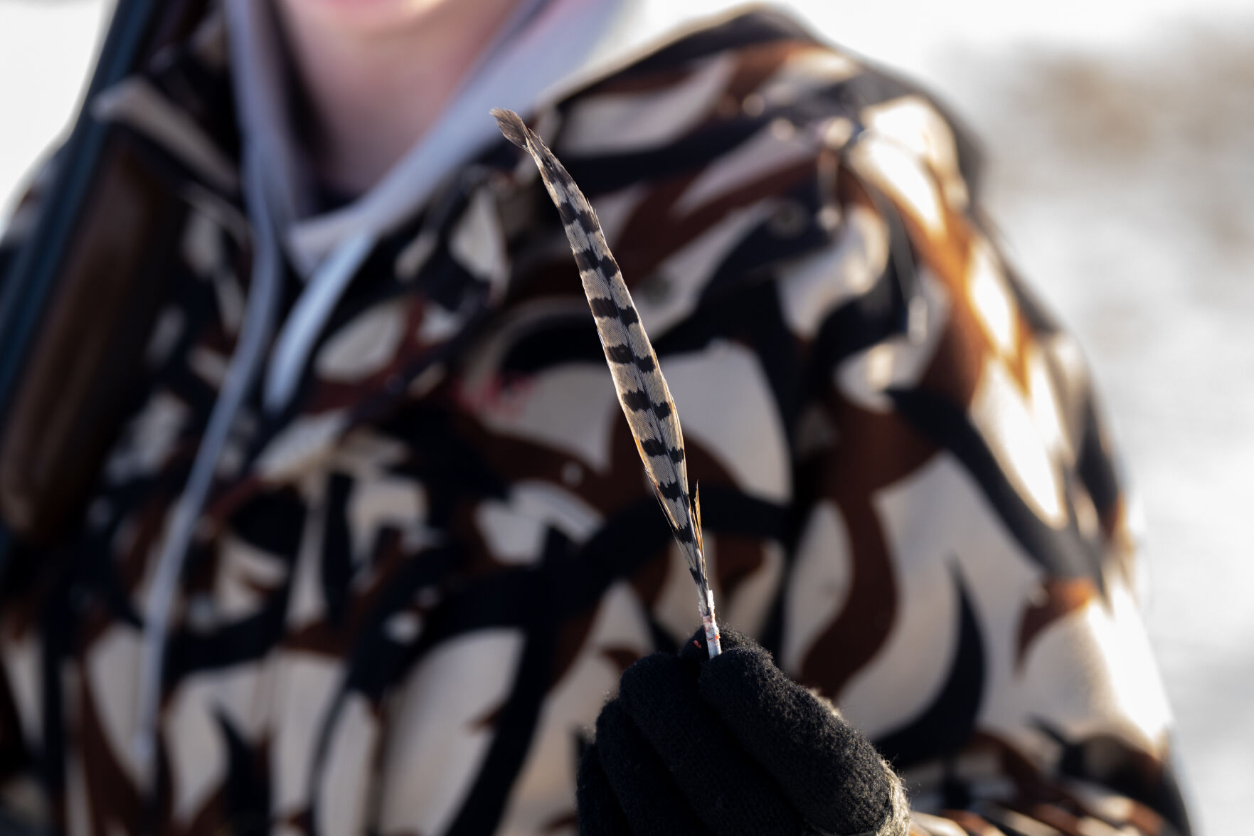 Hayden Jawors holds up a pheasant feather